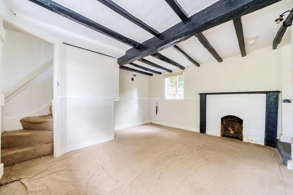 Lot: 32 - MID-TERRACED PROPERTY FOR REFURBISHMENT - Living room with exposed beams and fire place